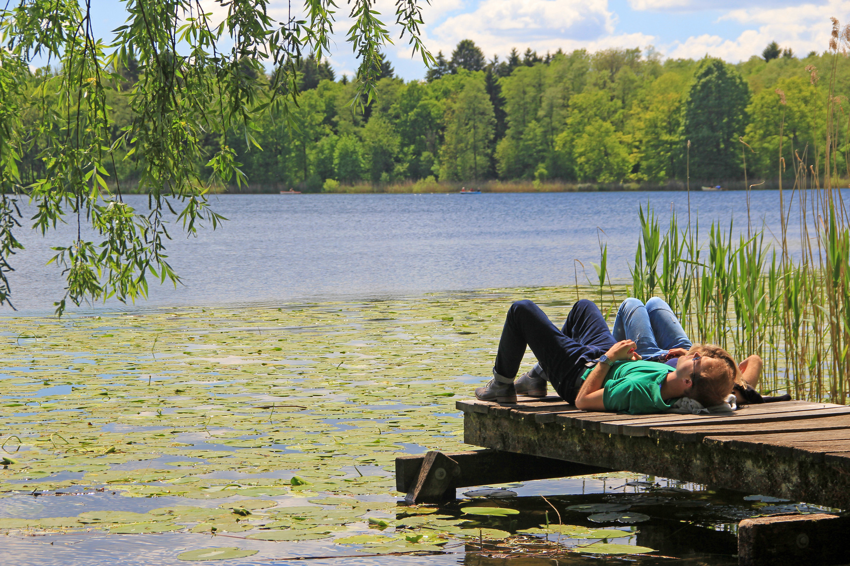 Paar genießt einen ruhigen Moment auf einem Steg am See