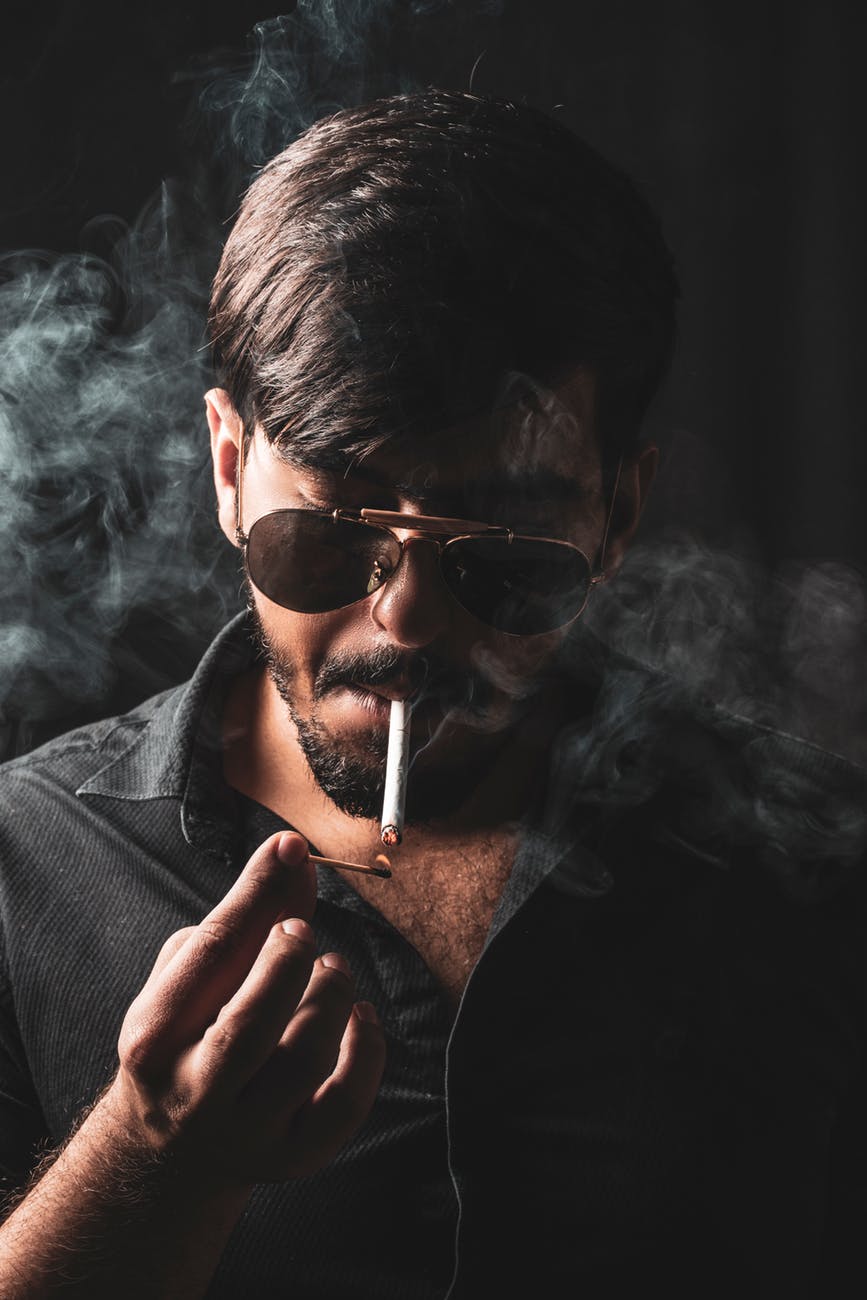 selective focus photography of man smoking cigarette